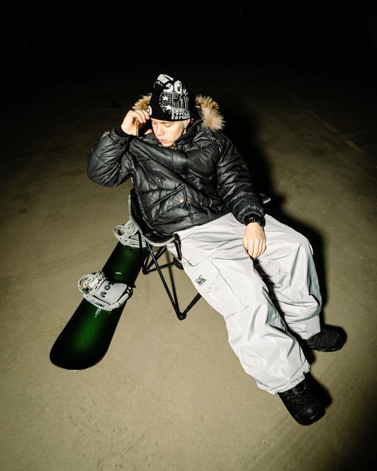 Rider assis la nuit avec son snowboard