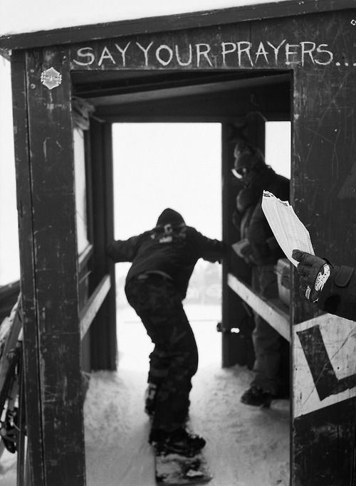 Snowboarder qui passe une porte marquée Say your prayers